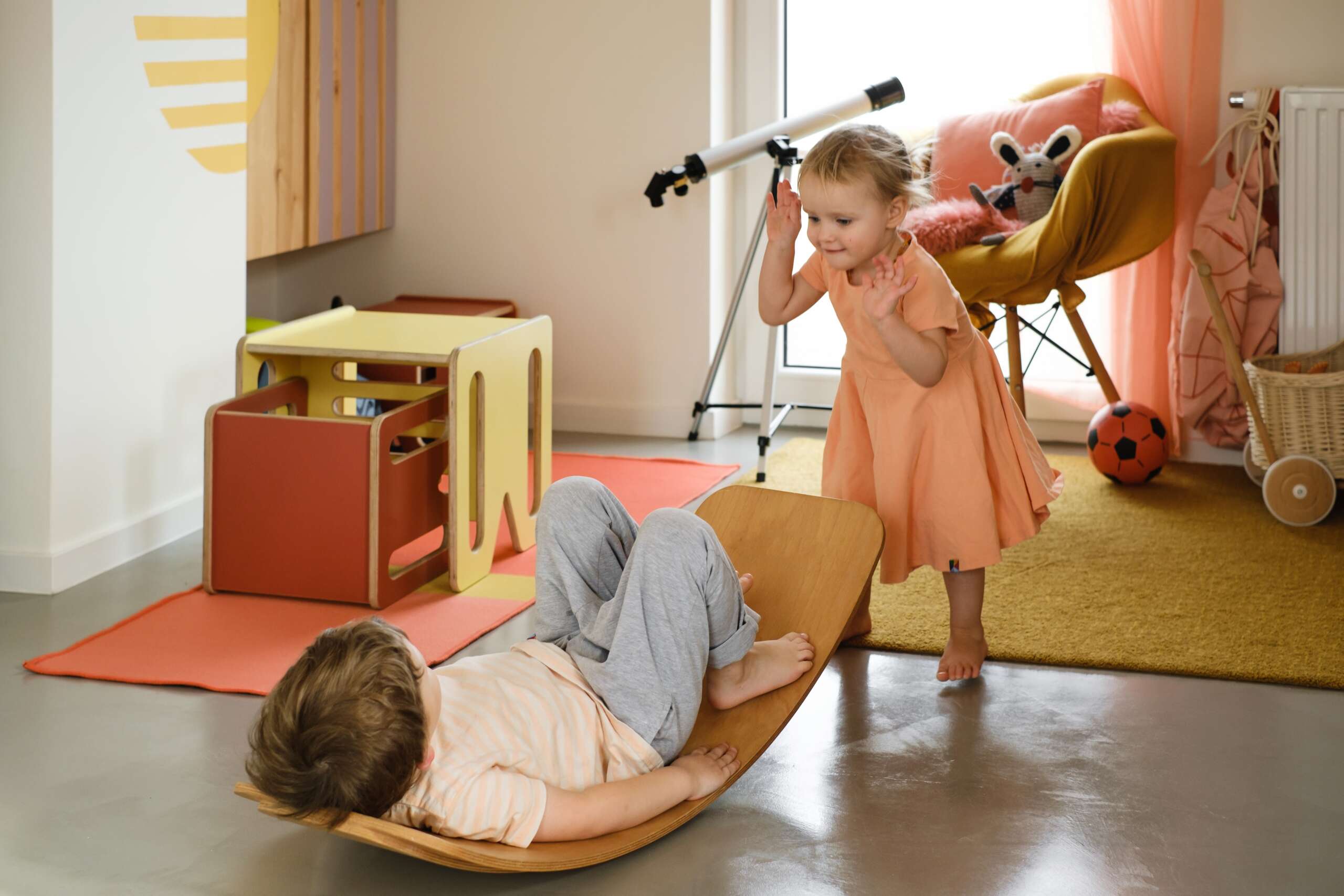 child playing on balance board for toddlers in kids room