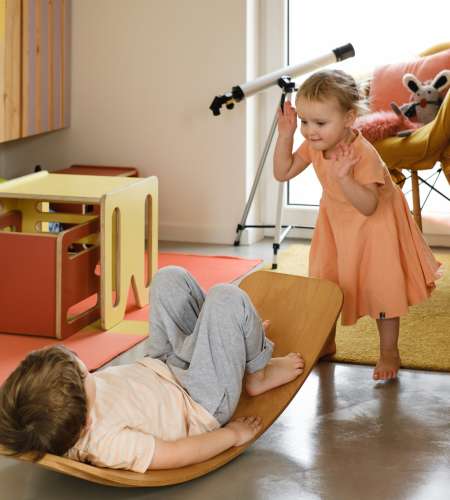 About child playing on balance board for toddlers in kids room